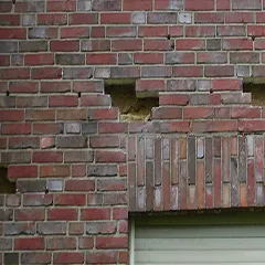 Löcher in einer Hauswand. Unter den Löchern befindent sich ein Rollo.