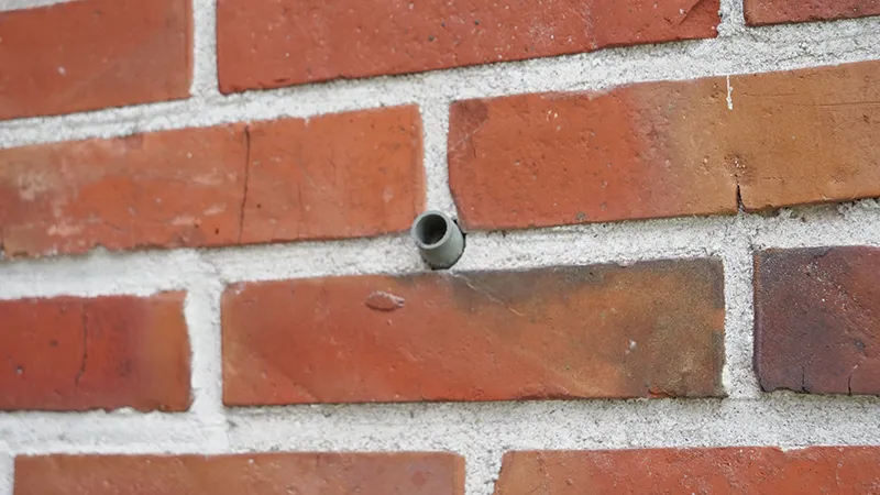 Bild von einem Einfülltutzen, der in die Mauer eingeführt wurde.